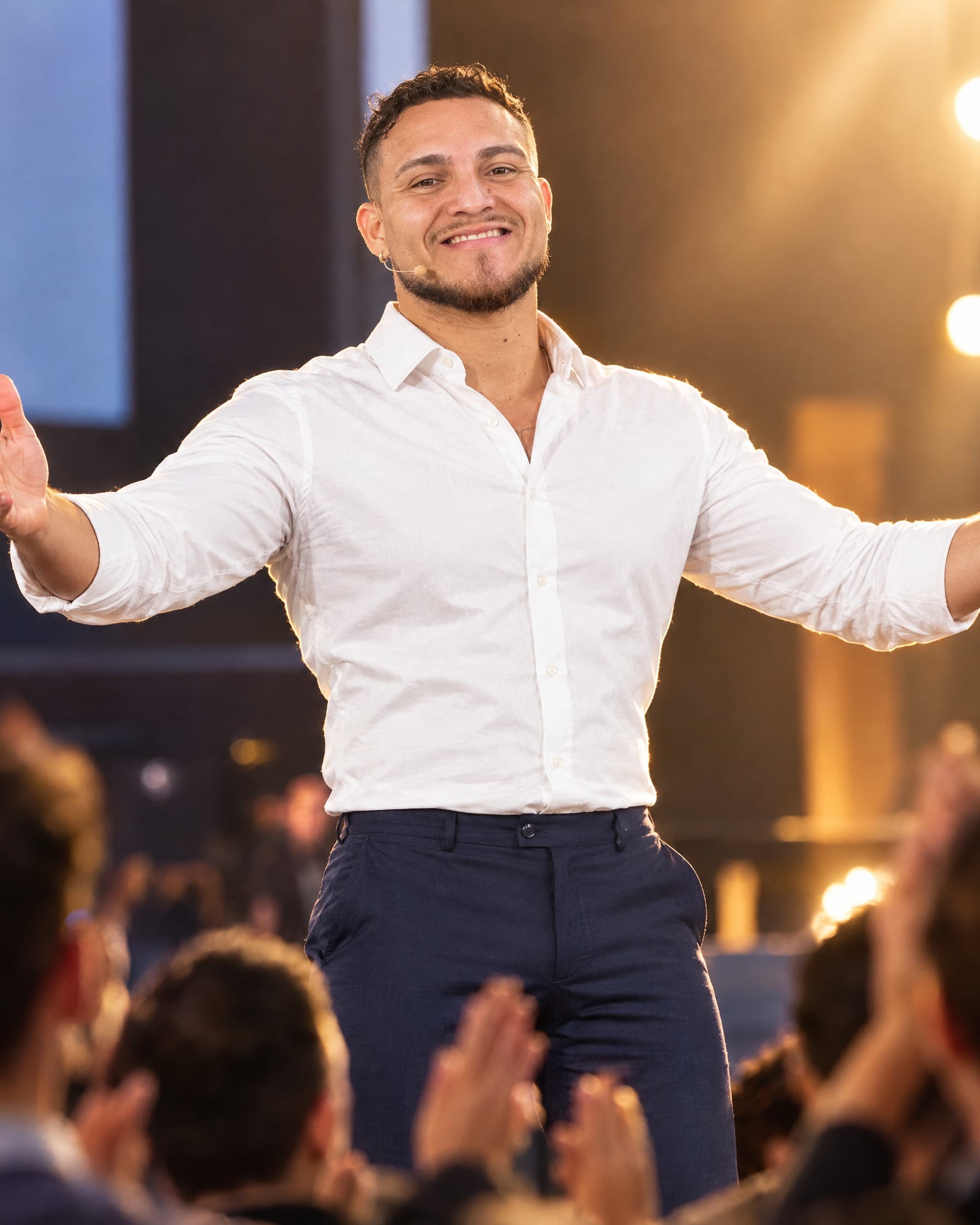 Nevin Henriquez on stage with his arms open